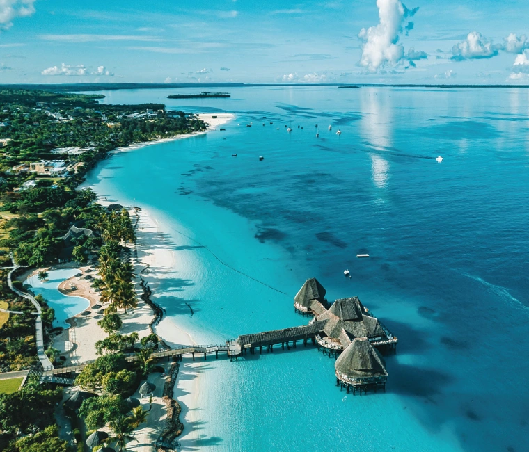 Pristine Zanzibar beach with turquoise waters and palm trees, showcasing top tropical holiday destinations in Tanzania.