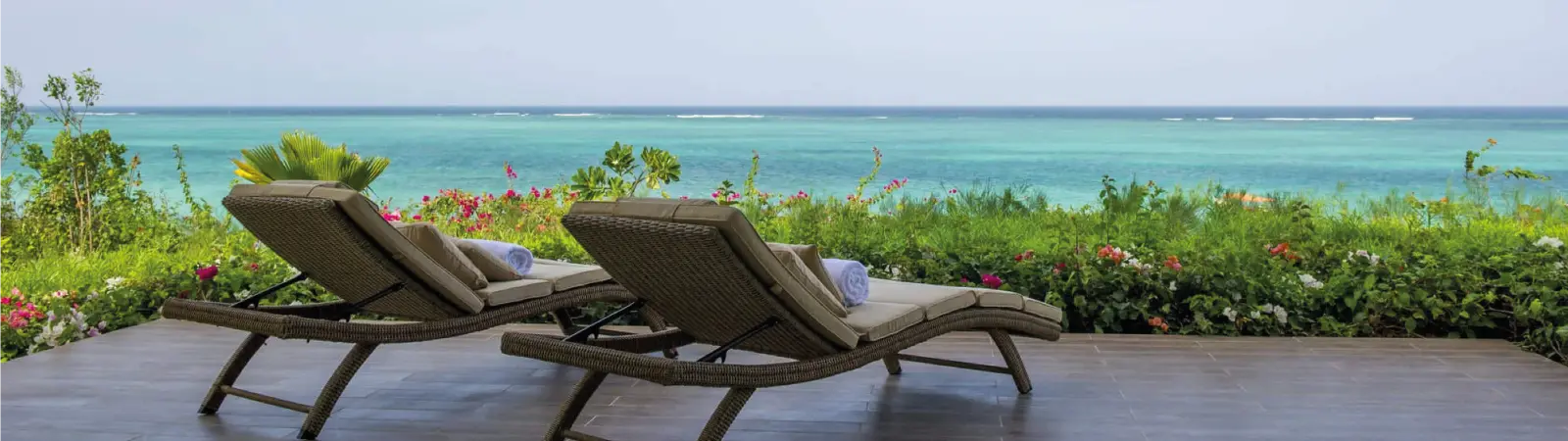 A relaxing sunbed on pristine white sand facing the gentle waves and breeze of the Zanzibar coast.